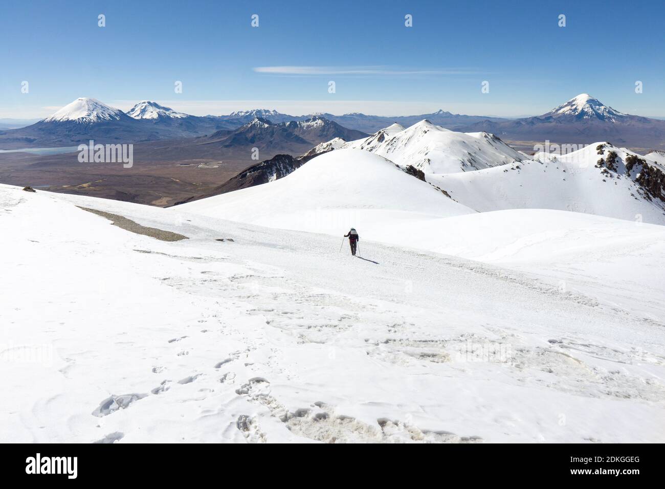 Femme alpiniste sur Acotango (6052) route normale avec des volcans Parinacota, Pomerape et Sajama en arrière-plan, Bolivie Banque D'Images