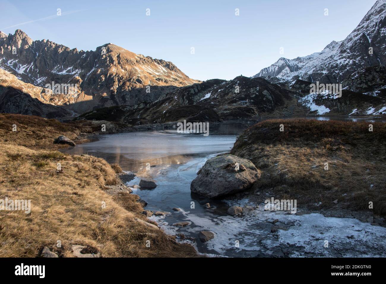 premiers rayons de soleil sur un lac de montagne à moitié gelé Banque D'Images