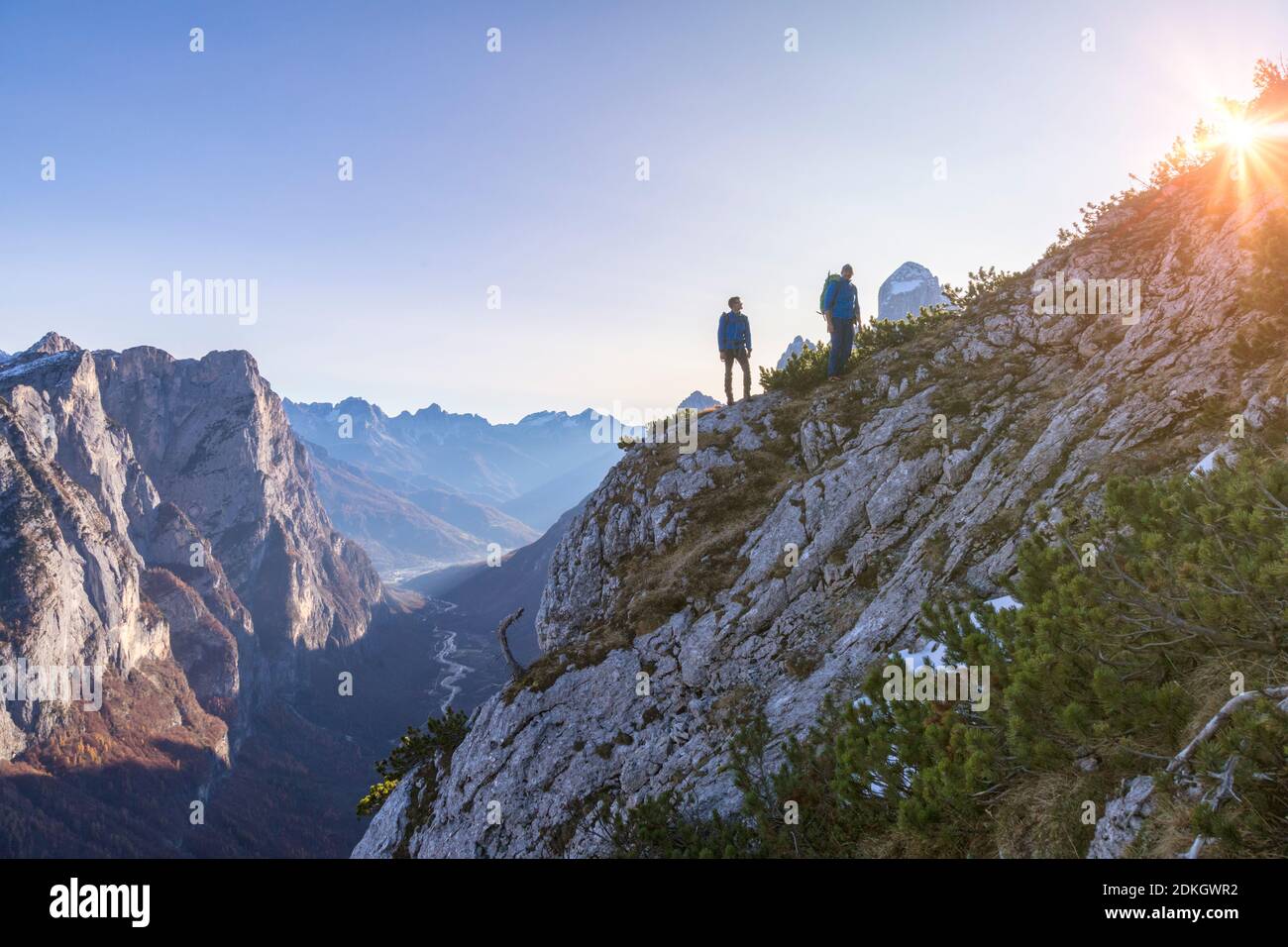 Italie, Vénétie, Belluno, Taibon Agordino, Dolomites. Deux randonneurs grimpent un mur surplombant la vallée de san lucano, sur la gauche le groupe Pale di San Lucano Banque D'Images