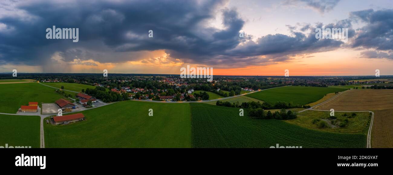 Un tir de drone d'un coucher de soleil d'une ville, tandis que des nuages de pluie sont à venir., Oberhaching de Bavière en Allemagne. Banque D'Images