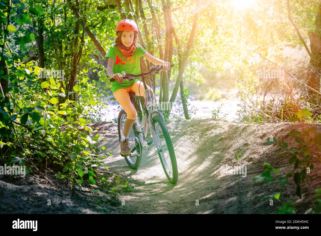Italie, Vénétie, Belluno, Agordino, petite fille (10 ans) s'amuse avec sa bicyclette le long d'un chemin forestier Banque D'Images