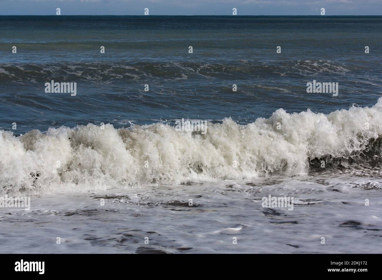 Le vent pousse les vagues de la mer à la plage les provoquant de se briser violemment contre la côte Banque D'Images