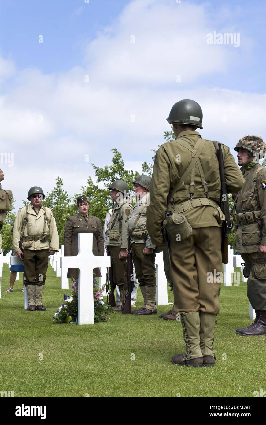 Les réacteurs historiques des uniformes de l'armée américaine de la Seconde  Guerre mondiale placent les fleurs sur une tombe, au cimetière américain de  Normandie, à Colleville-sur-Mer, en Normandie, en France Photo Stock -