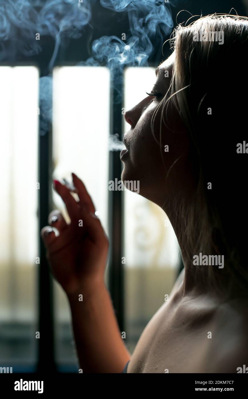 Une fille fume la cigarette sur fond noir Photo Stock - Alamy