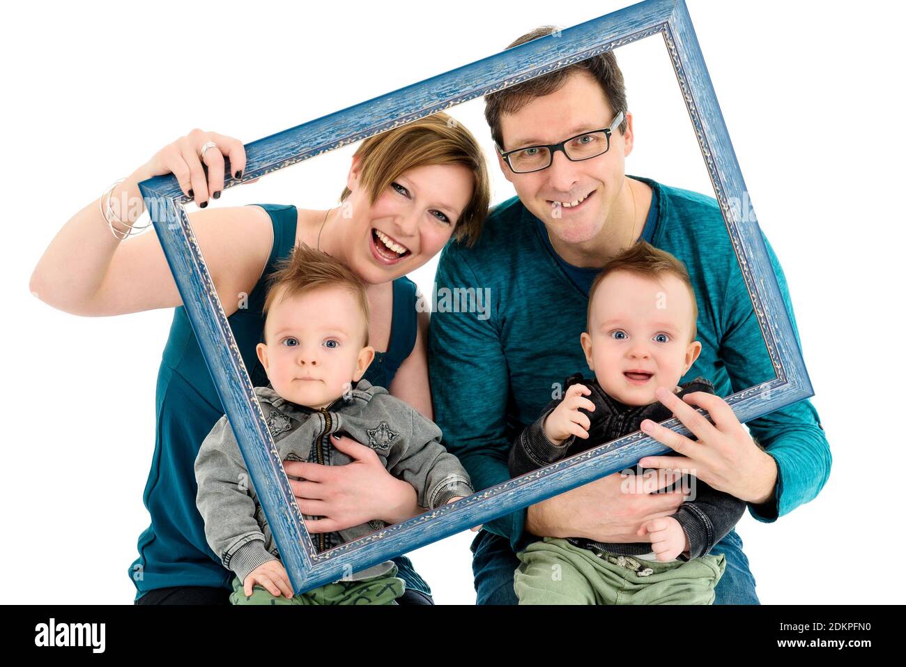 Une famille heureuse avec des jumeaux est en train de rire. Qu'ils soient  en possession d'un cadre photo pour faire un effet créatif sur portrait de  famille. Isolé sur blanc Photo Stock -