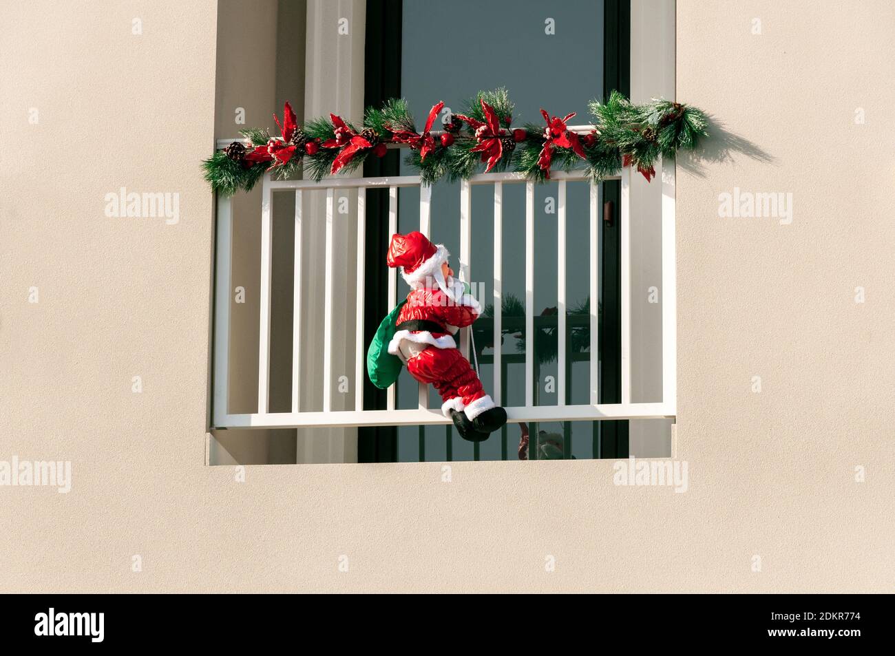 Le Père Noël enneigé monte le balcon sur la corde Banque D'Images