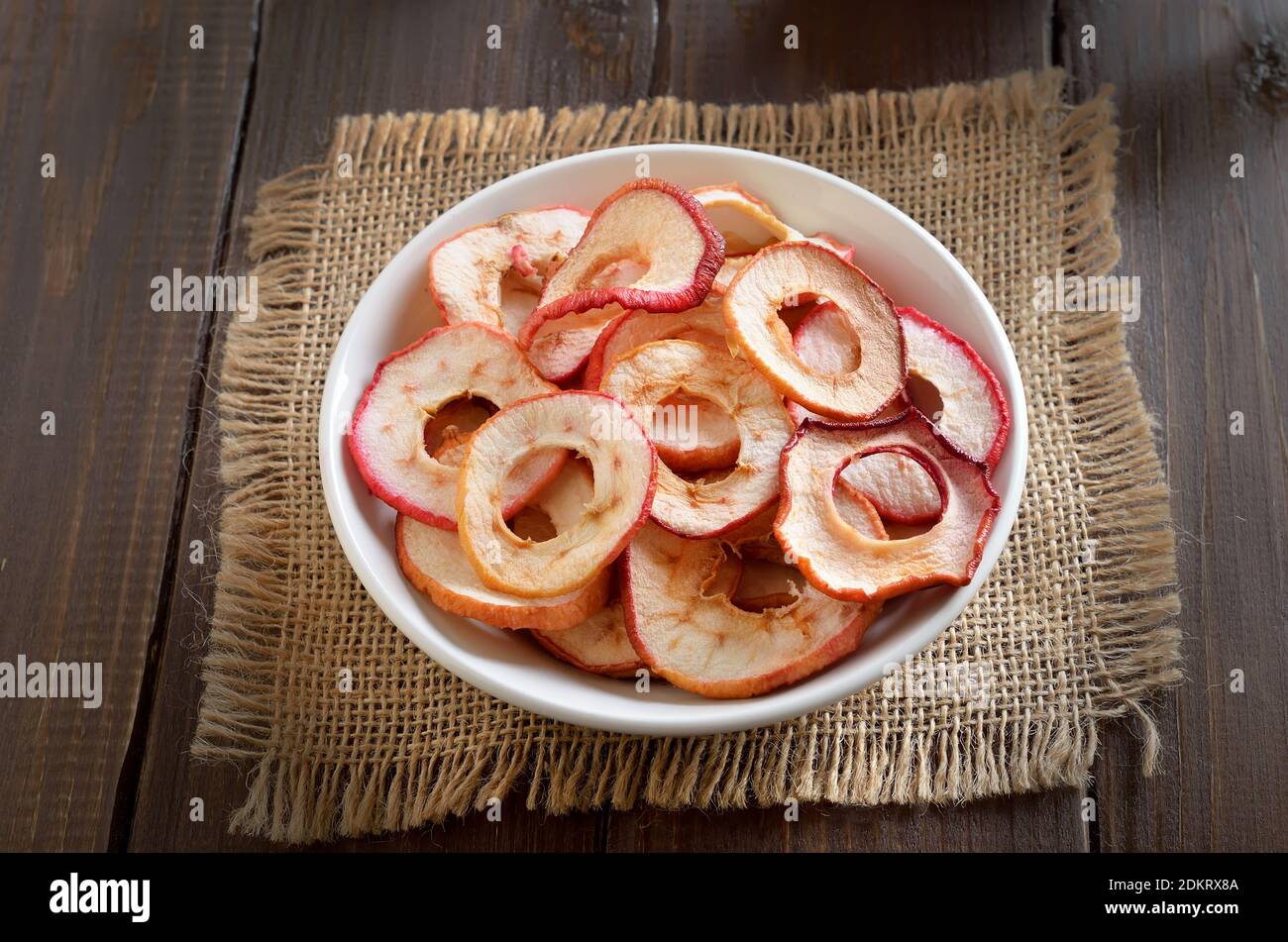 Rondelles de pomme séchées dans un bol blanc. Plats végétariens Banque D'Images