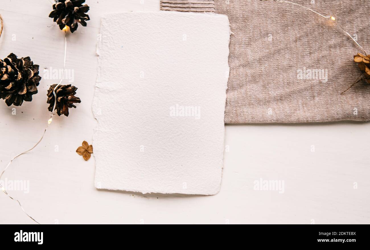 Pose plate style hygge. Liste de souhaits de Noël. Papier fait à la main noué avec des fils artisanaux. Enveloppe maquette de lettre, cônes de pin, fil d'artisanat. Banque D'Images
