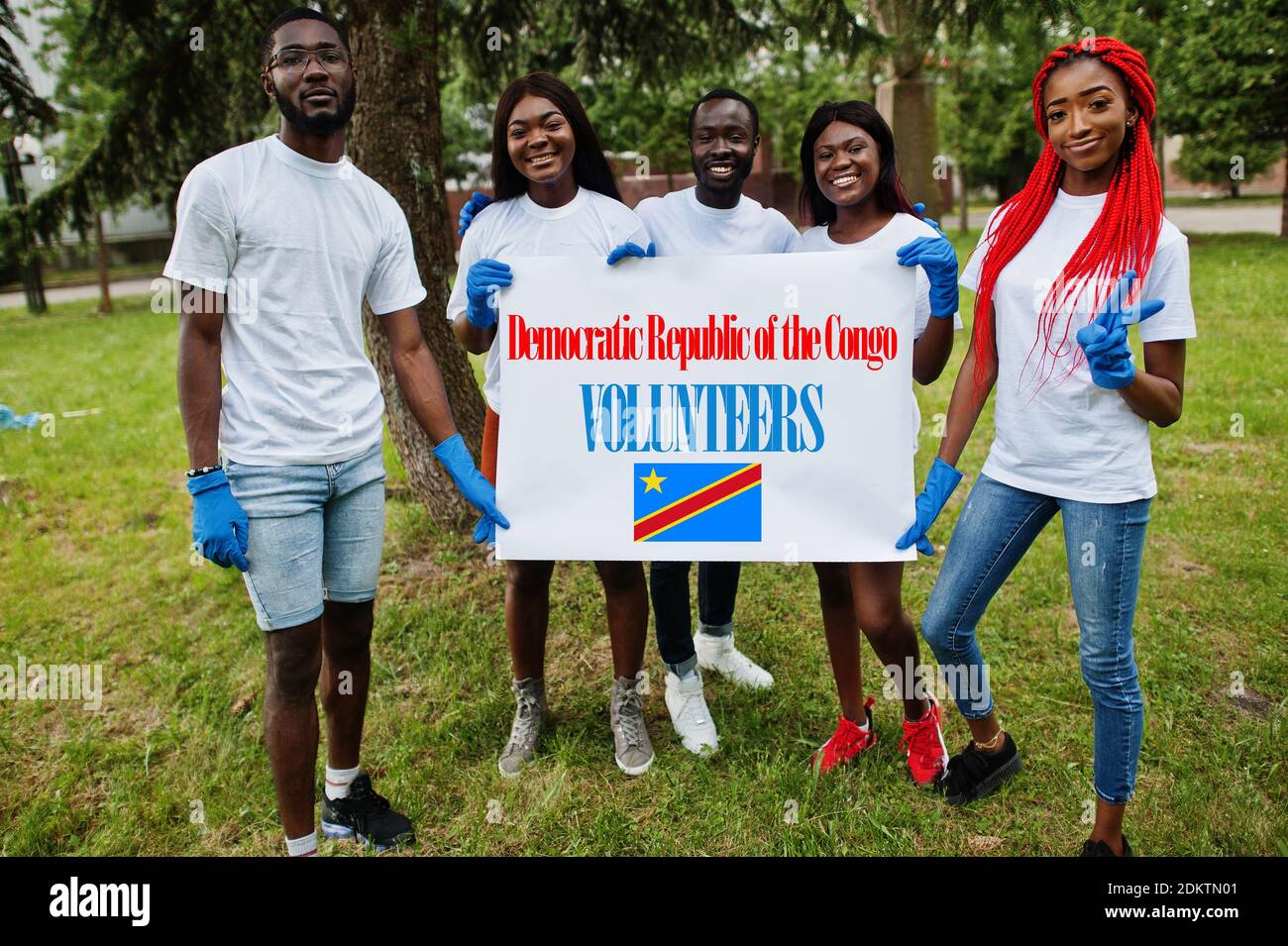 Groupe de volontaires africains heureux tenir vide avec le drapeau Congo RDC dans le parc. Les pays africains se sont portés volontaires, associations caritatives, personnes et écologie. Banque D'Images