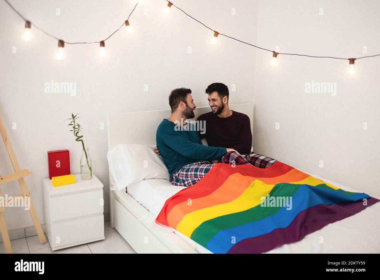 Gay hommes couple ayant des moments tendres assis sur le lit à la maison - Homoseal, amour et concept de relation - foyer principal sur le visage de type droit Banque D'Images