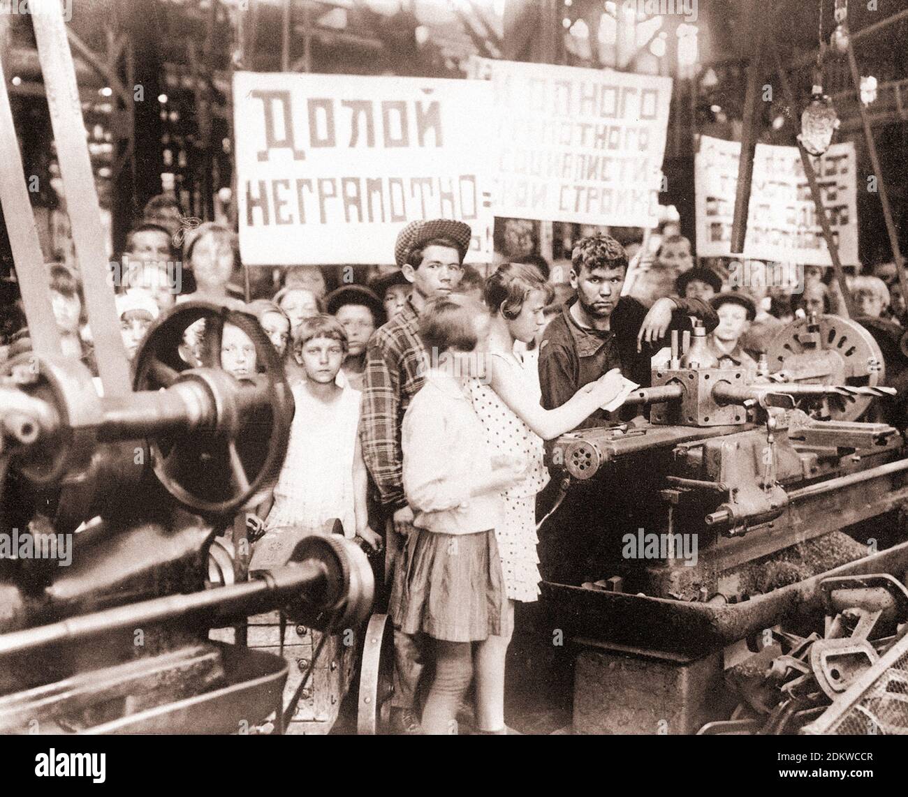 Des écoliers soviétiques rendent visite à des travailleurs dans l'une des usines. URSS. années 1930. D'un livre de propagande soviétique Banque D'Images