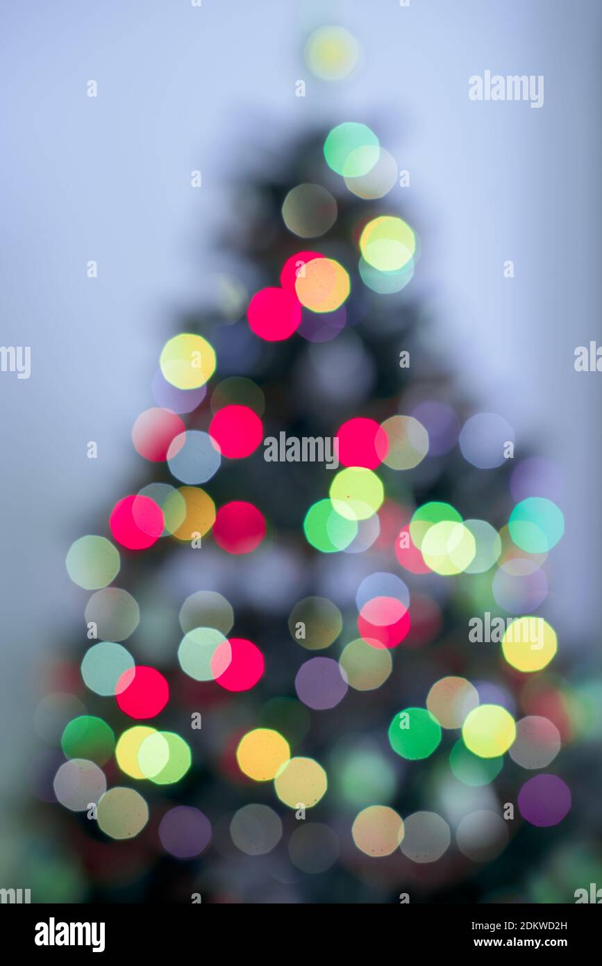 Flou sapin de Noël lumières décoration sur fond violet et flocons de neige Banque D'Images