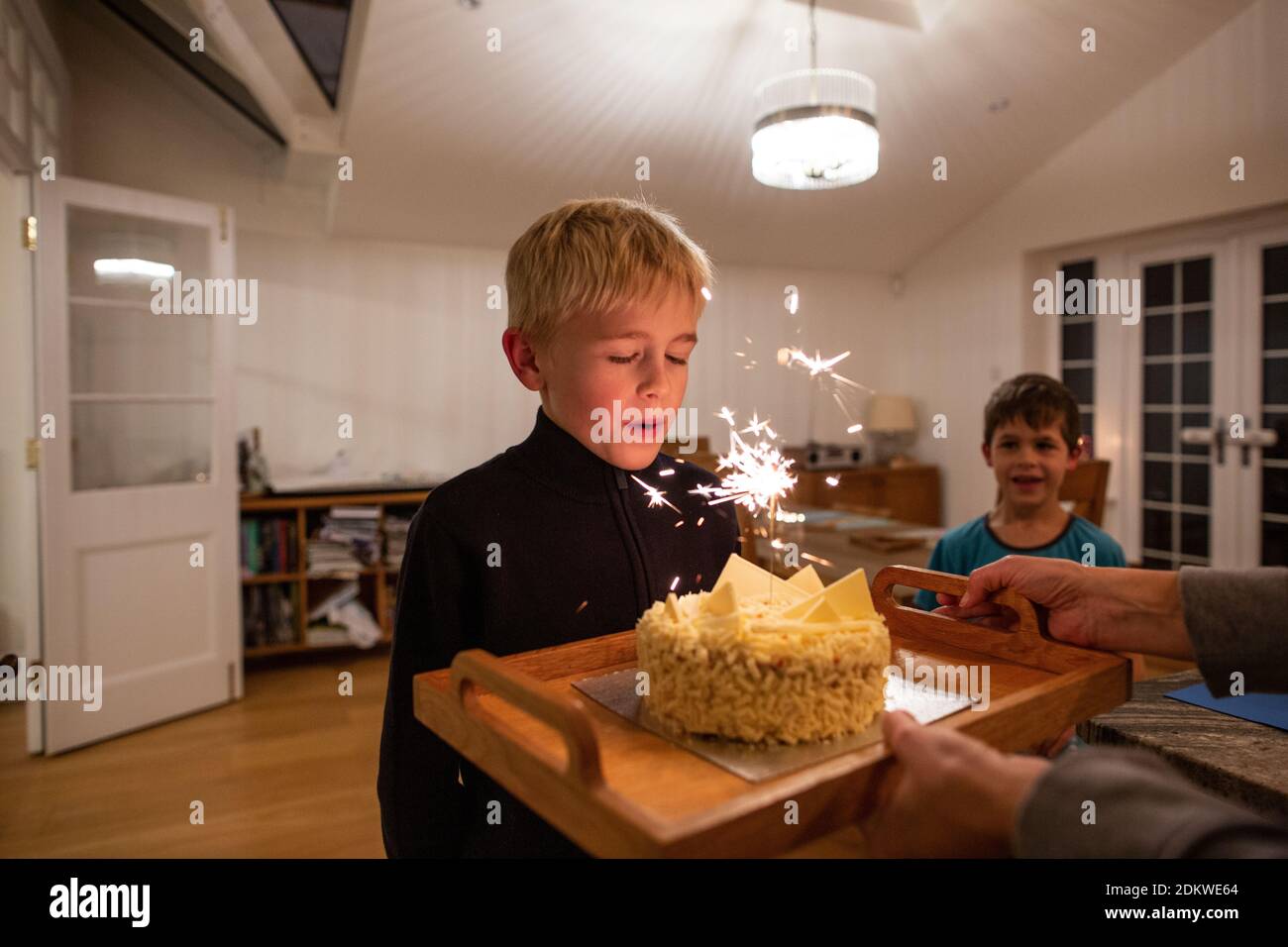 Un Garcon De 10 Ans Souffle La Bougie Sur Son Gateau D Anniversaire Tandis Que Son Jeune Frere Regarde Angleterre Royaume Uni Photo Stock Alamy