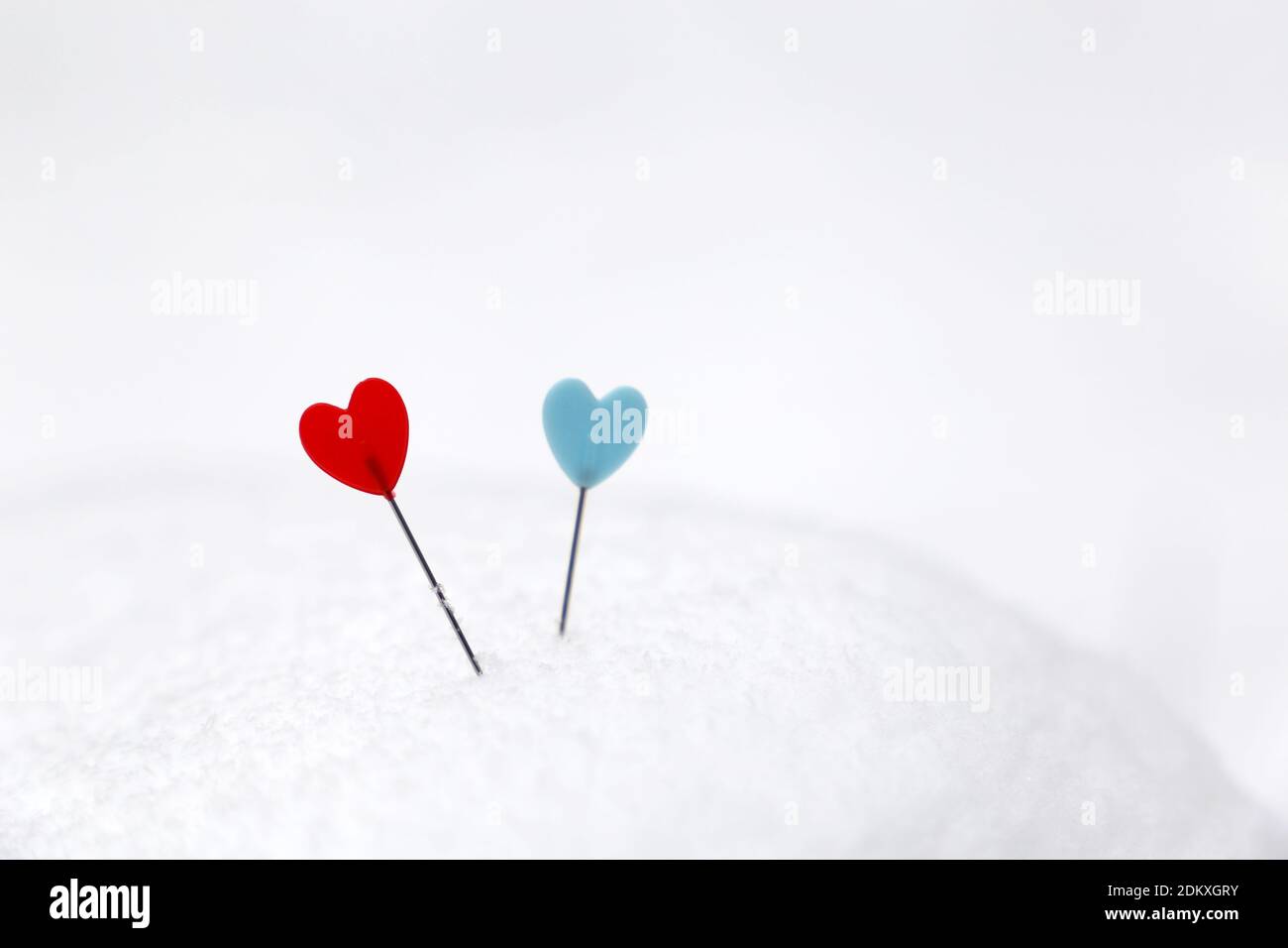 Coeurs rouges et bleus sur une neige. Fond pour carte de vœux romantique, Saint-Valentin Banque D'Images