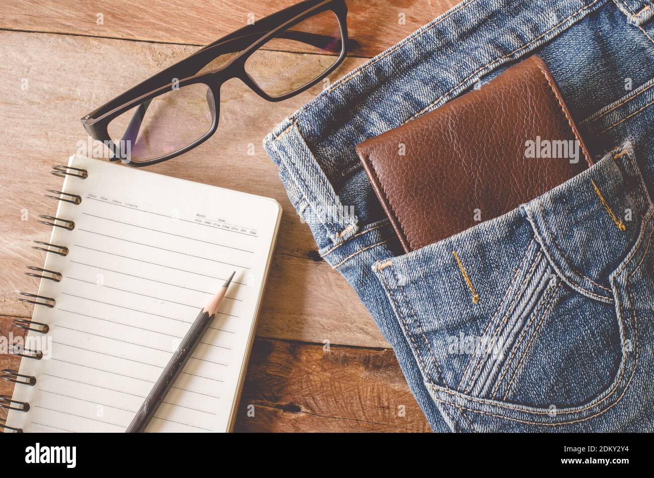 Portefeuille par Livre et lunettes en Jean poche sur la table Banque D'Images