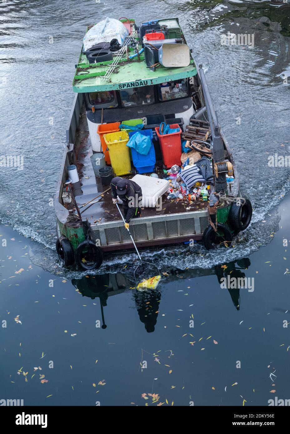 Berlin, Allemagne. 16 décembre 2020. Un homme avec un filet d'atterrissage  recueille les ordures flottant sur et sous l'eau d'un bateau à ordures  appartenant à 'Wasser und Kulturbau Leegebruch GmbH', qui navigue