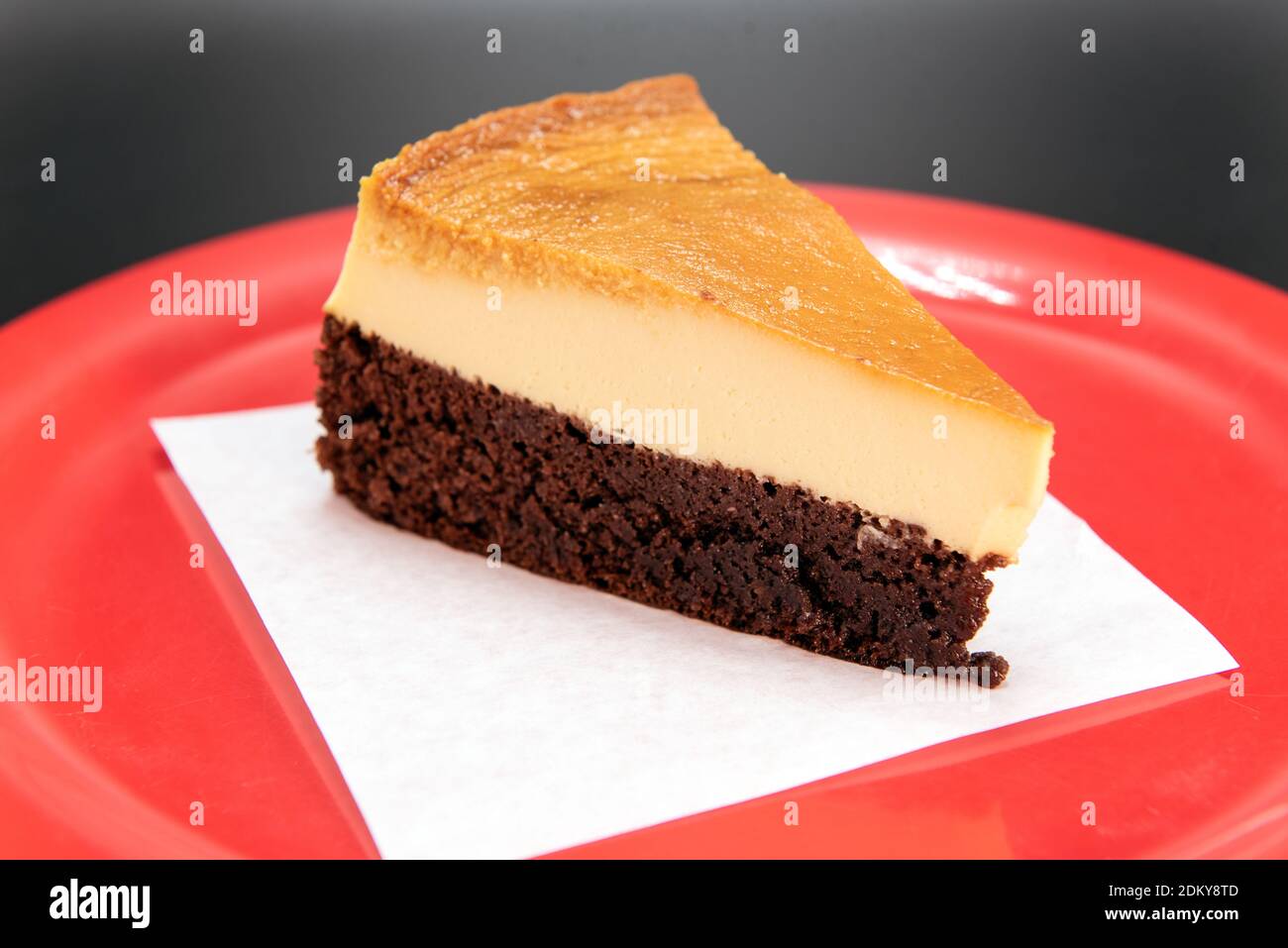 Couche De Chocolat Au Fond Du Dessert Flan Mexicain Coupee En Coin Et Presentee Sur Une Assiette Rouge Photo Stock Alamy