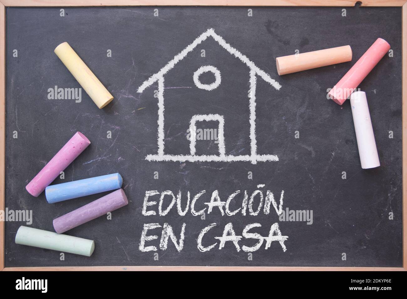 La scolarisation à domicile en espagnol sur un tableau noir avec quelques craies dessus. Modèle d'éducation alternative. Banque D'Images