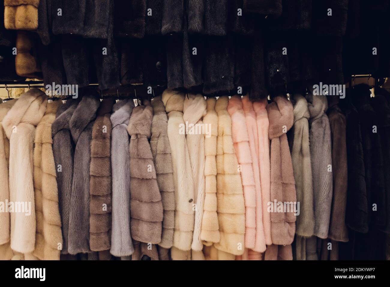 Manteaux de vison de luxe. Manteaux de fourrure gris, bruns, de couleur perle sur la vitrine du marché. Le meilleur cadeau pour les femmes est un manteau de vison. Vêtements d'extérieur. Gros plan Banque D'Images