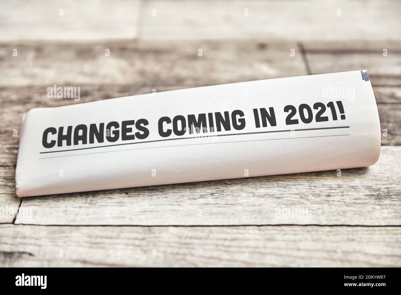 Les changements à venir en 2021 sont inscrits sur la page d'accueil d'un journal plié sur une table en bois Banque D'Images