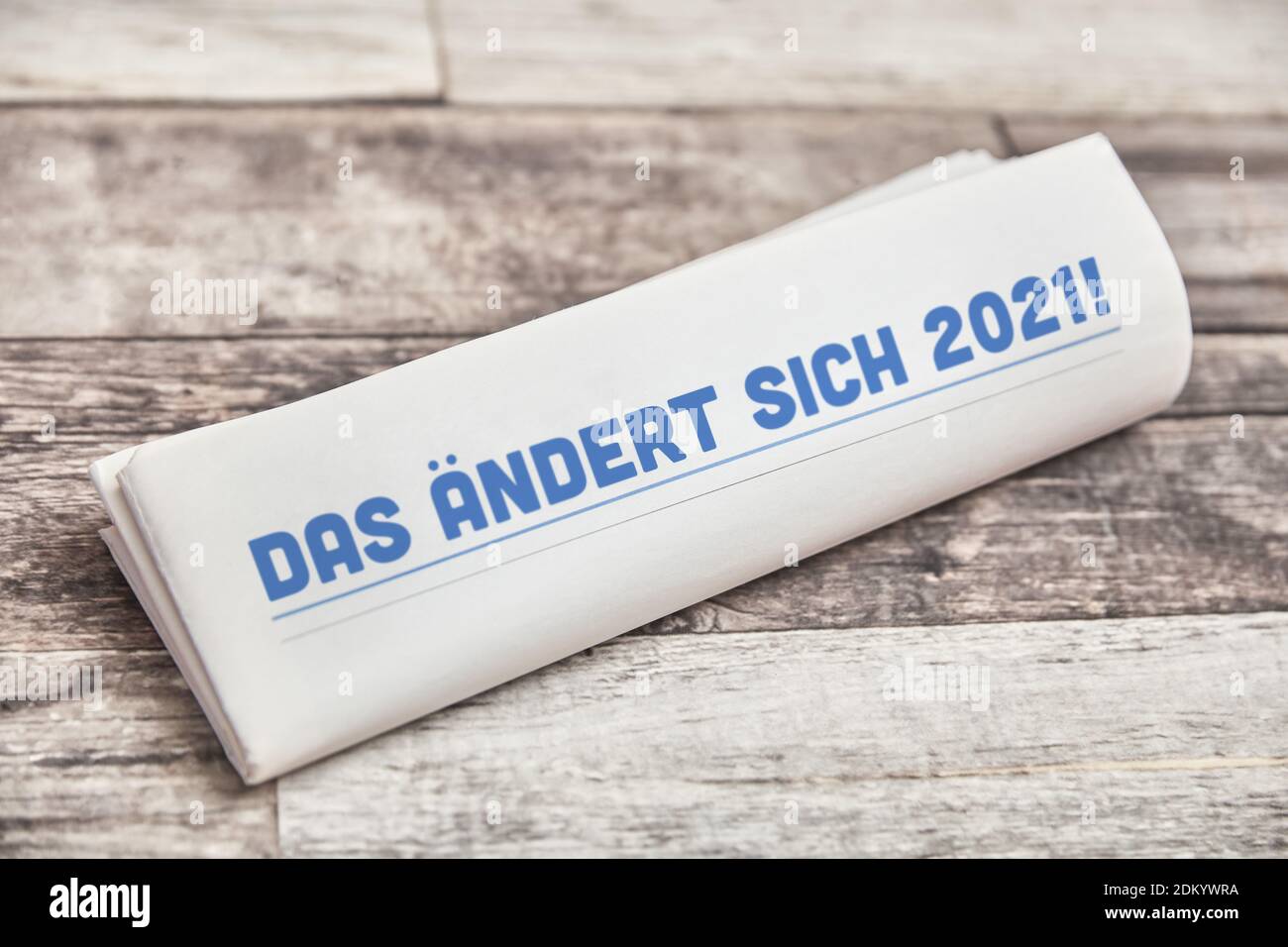 DAS ändert sich 2021 (allemand: Qui changera en 2021), il dit sur la première page d'un journal plié sur une table en bois Banque D'Images