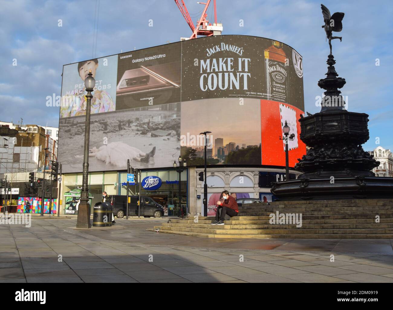 Londres, Royaume-Uni. 16 décembre 2020. Un homme portant un masque comme mesure préventive contre la propagation du covid-19 se trouve dans un Piccadilly Circus vide. La capitale a été transférée dans le niveau 3, le plus haut niveau de restrictions, à mesure que les cas de coronavirus se répandent, avec la fermeture de bars, restaurants, cinémas et théâtres. Crédit : SOPA Images Limited/Alamy Live News Banque D'Images