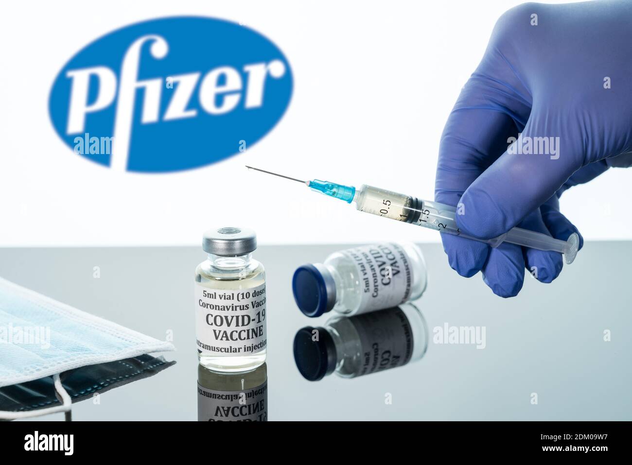 Morgantown, WV - 16 décembre 2020 : petite bouteille de vaccin contre le coronavirus avec seringue avec fond du logo Pfizer Banque D'Images