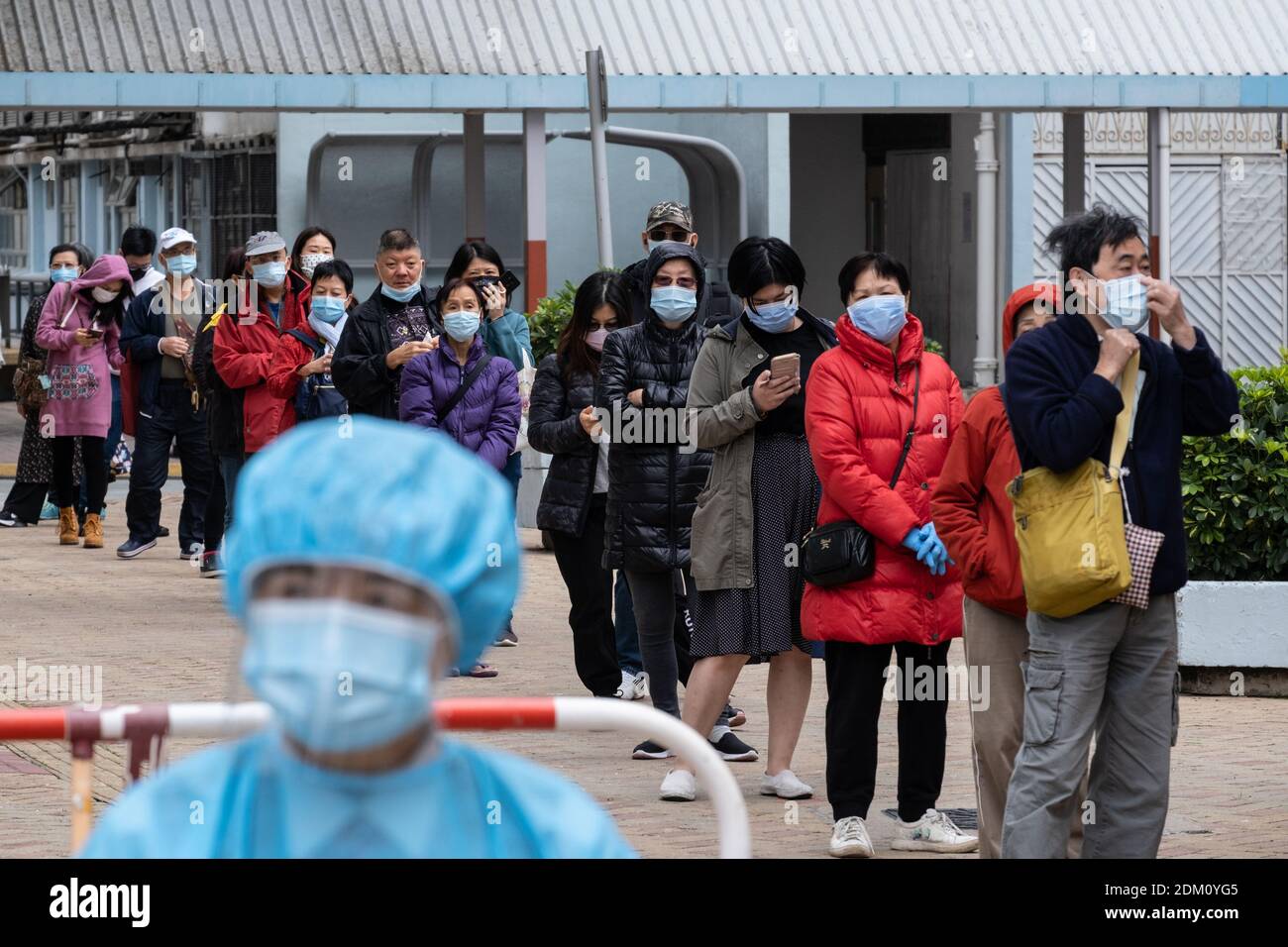 Hong Kong, Chine. 16 décembre 2020. Les résidents portant un masque facial comme précaution contre la propagation de covid-19 dans une file d'attente pendant les essais.le gouvernement de Hong Kong a mis en place des centres d'essais temporaires pour fournir des tests gratuits de la (COVID-19) pour les résidents alors que la ville fait face à la quatrième vague de cas. Crédit : SOPA Images Limited/Alamy Live News Banque D'Images