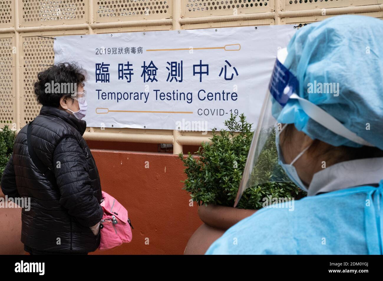 Hong Kong, Chine. 16 décembre 2020. Un travailleur médical (R) portant un équipement de protection individuelle EPI vu aider un résident pendant les essais.le gouvernement de Hong Kong a mis en place des centres d'essais temporaires pour fournir des tests gratuits de la (COVID-19) pour les résidents alors que la ville fait face à la quatrième vague de cas. Crédit : SOPA Images Limited/Alamy Live News Banque D'Images