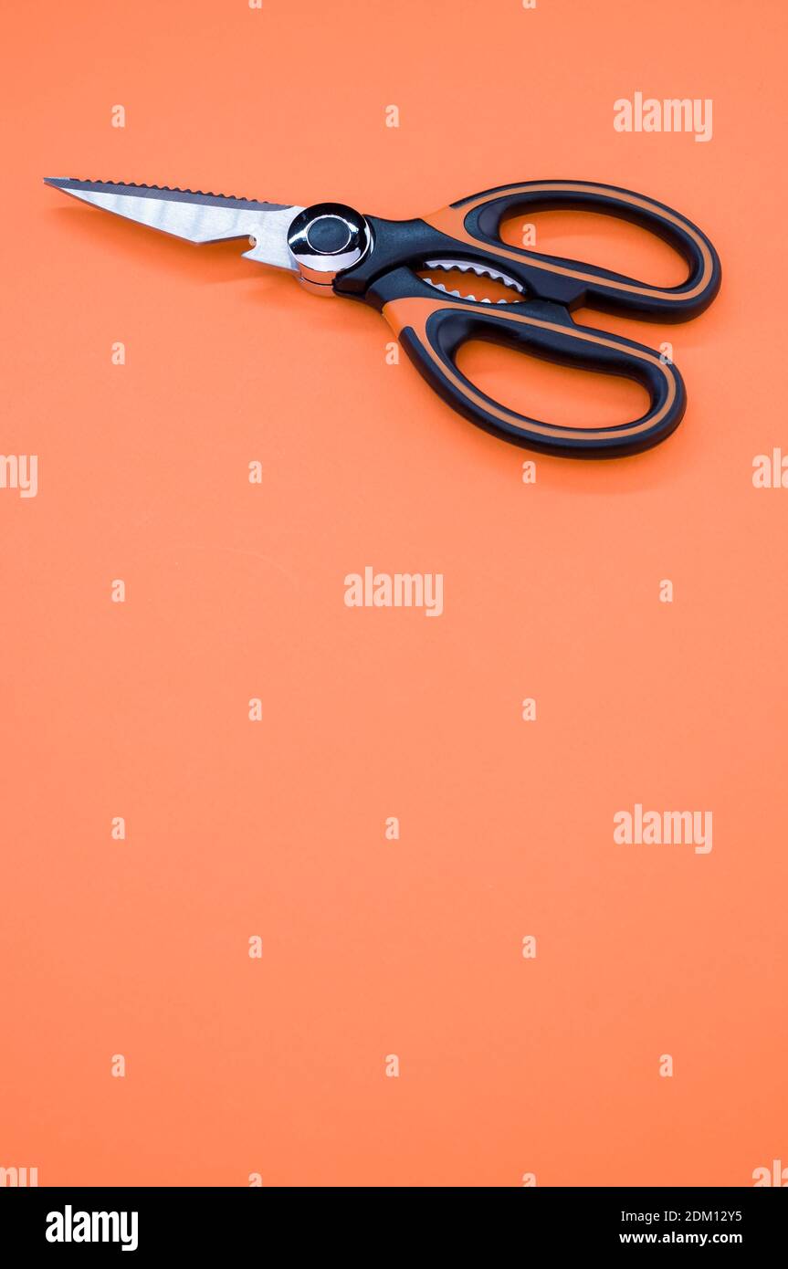 Un cliché vertical de ciseaux isolés sur fond rose. Outil de coupe avec lames zigzag, copier l'espace Banque D'Images