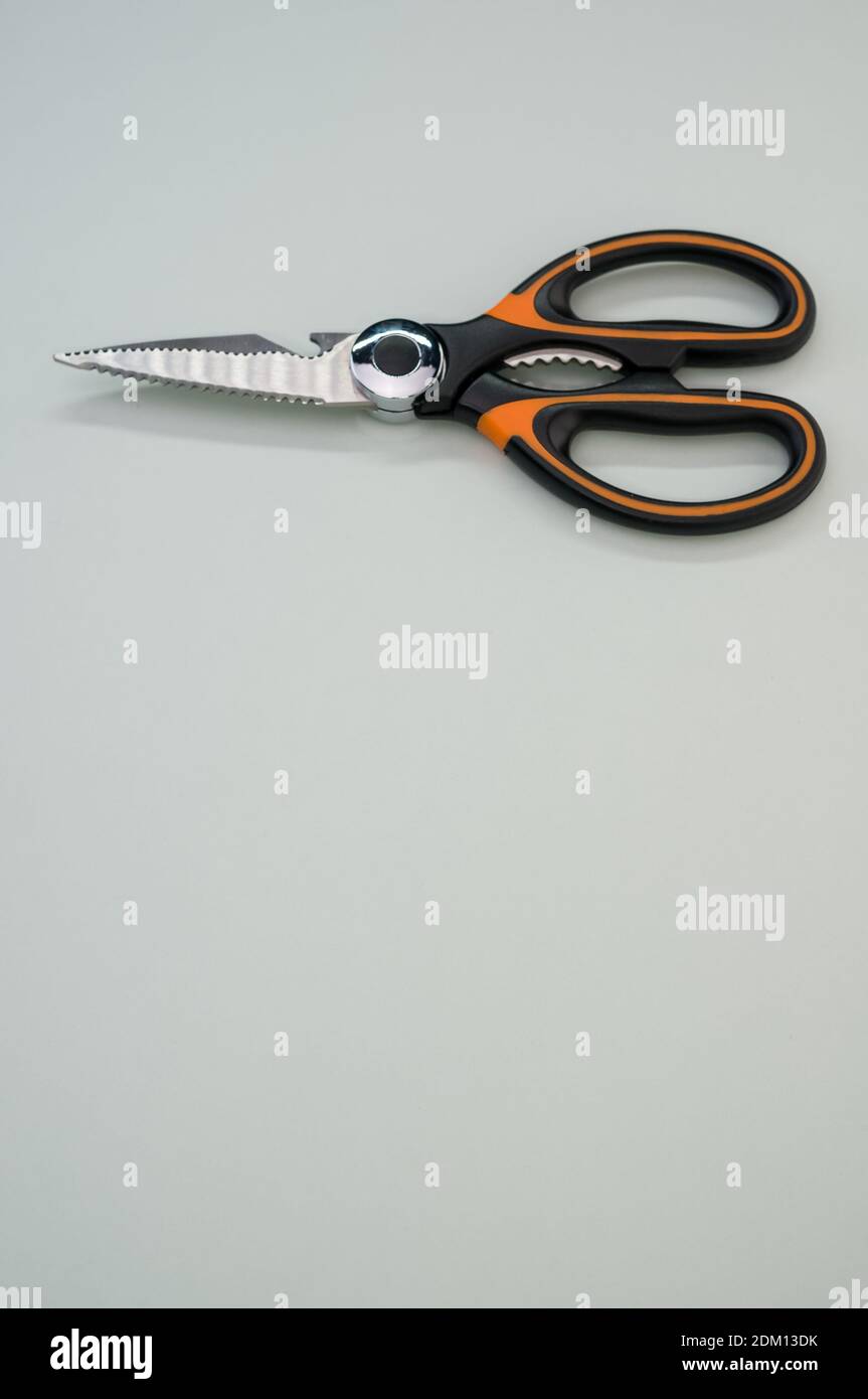 Un cliché vertical de ciseaux isolés sur fond bleu. Outil de coupe avec lames zigzag, copier l'espace Banque D'Images