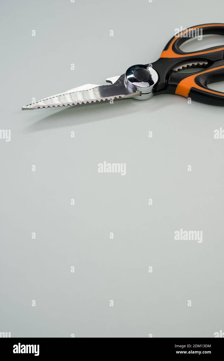 Un verticalshot de ciseaux isolés sur fond bleu. Outil de coupe avec lames zigzag, copier l'espace Banque D'Images