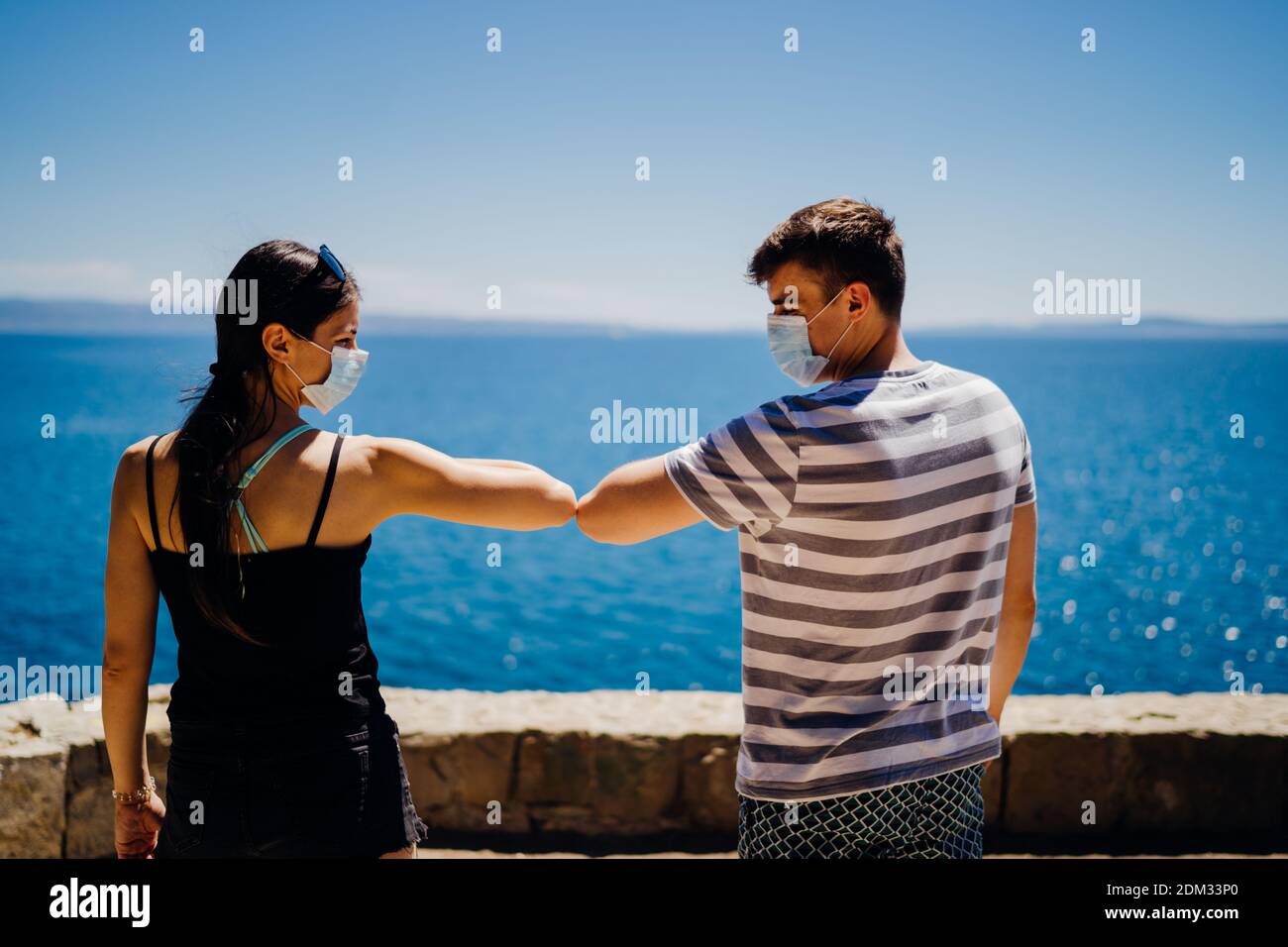 Deux amis avec des masques protecteurs saluent avec des coudes bomp.alternative salutation Pendant la quarantaine pour éviter tout contact physique.coronavirus COVID-19 maladie Banque D'Images