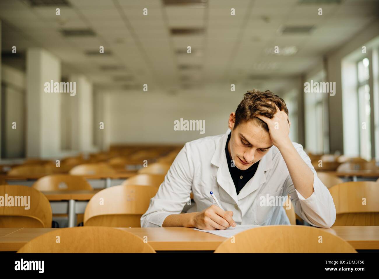 Professionnel de la santé remplissant un document, l'air épuisé, fatigué. Médecin écrivant un avis.examen de médecine, médecin prenant le test evalu Banque D'Images