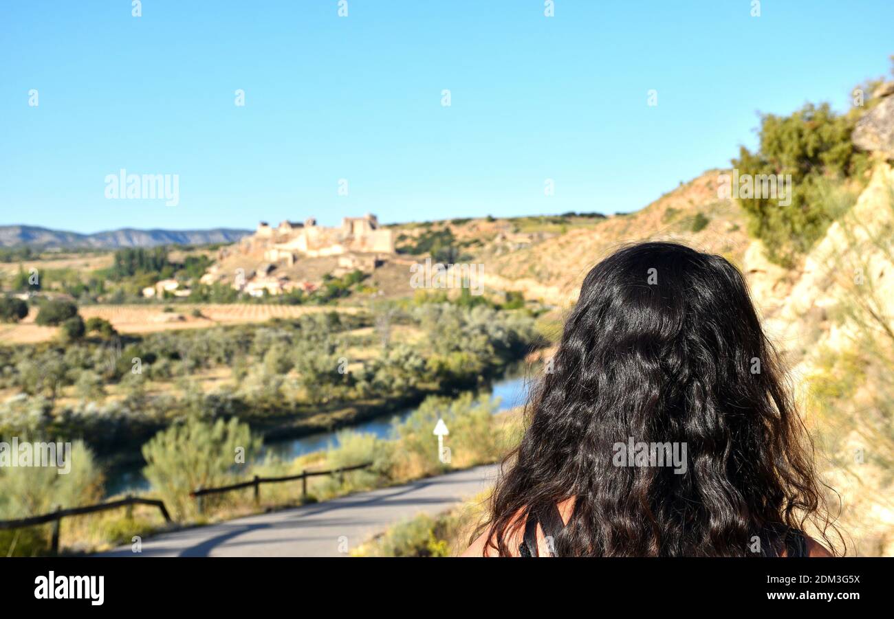 Touristes aux cheveux longs et sombres observant la ville de Zorita de los Canes et son château à distance. Tajo entre les deux. Banque D'Images