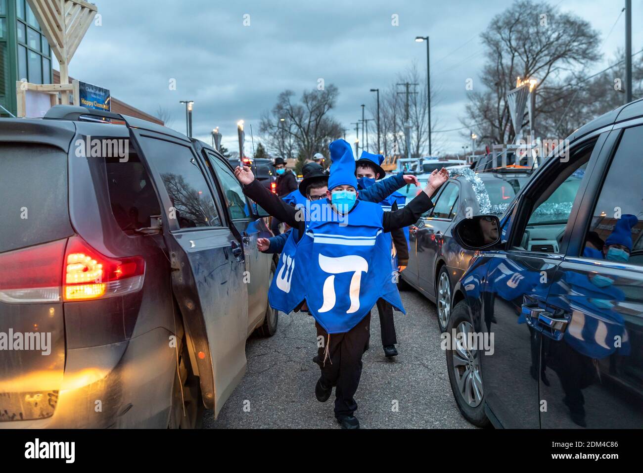 Southfield, Michigan - les garçons dansent entre les voitures alignées pour une voiture Top Menorah Parade la quatrième nuit de Chanukah. Banque D'Images
