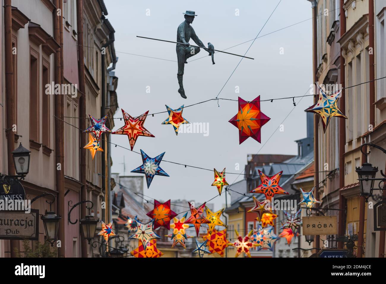 Lublin, Pologne - 29 décembre 2019 : le conjurer et les étoiles colorées illuminées comme décorations de Noël à la rue Grodzka dans la vieille ville Banque D'Images