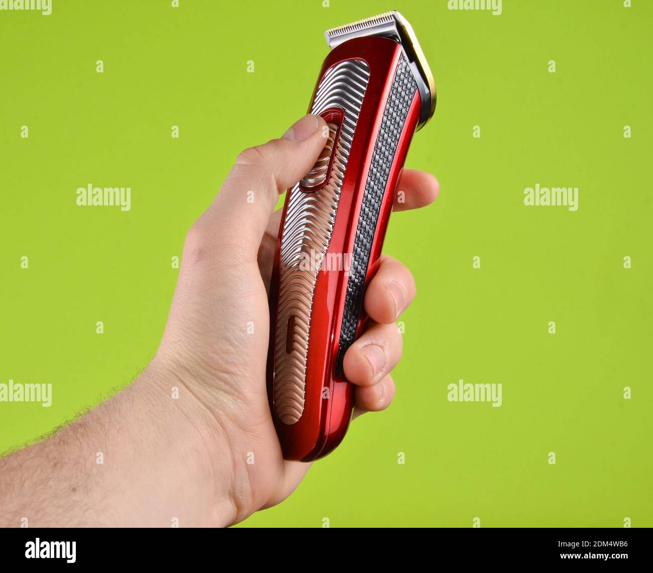 Tondeuse sans fil dans une main mâle isolée sur un green arrière-plan Banque D'Images