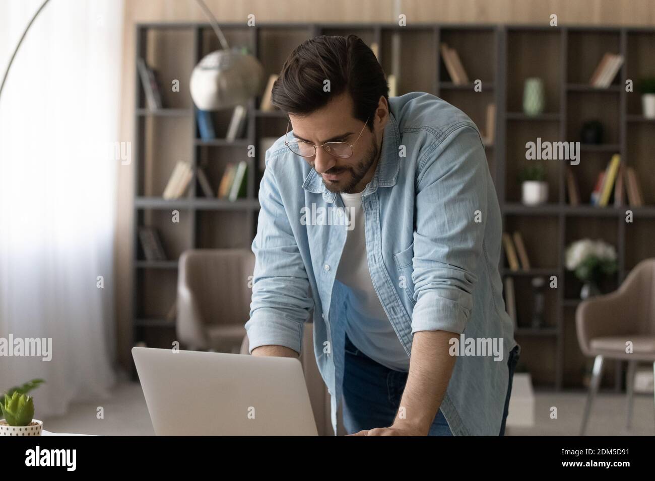 Un homme du Caucase travaille sur un ordinateur au bureau à domicile Banque D'Images