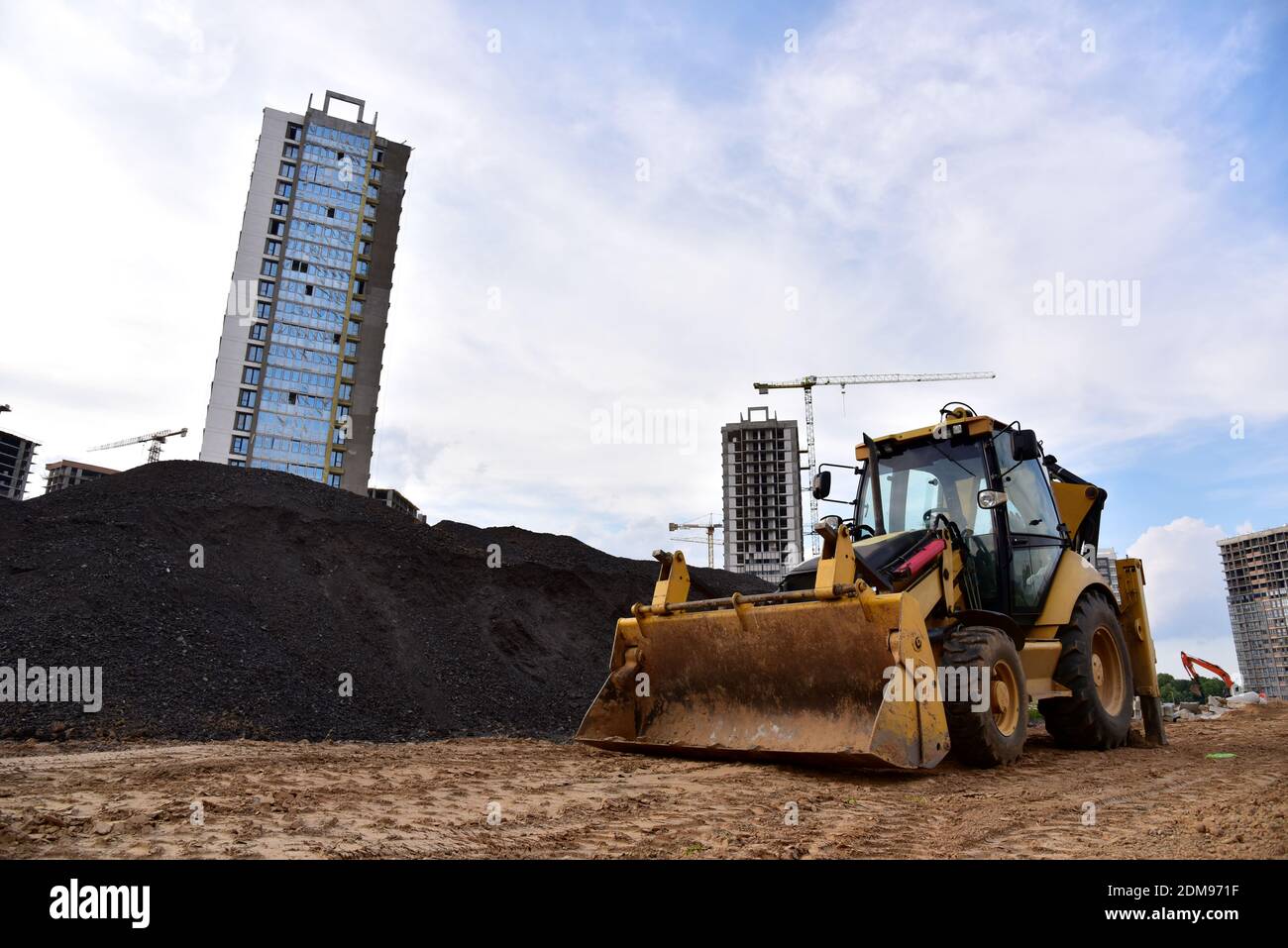 Bulldozer sur roues avec godet dans la rue dans la ville pendant la ...
