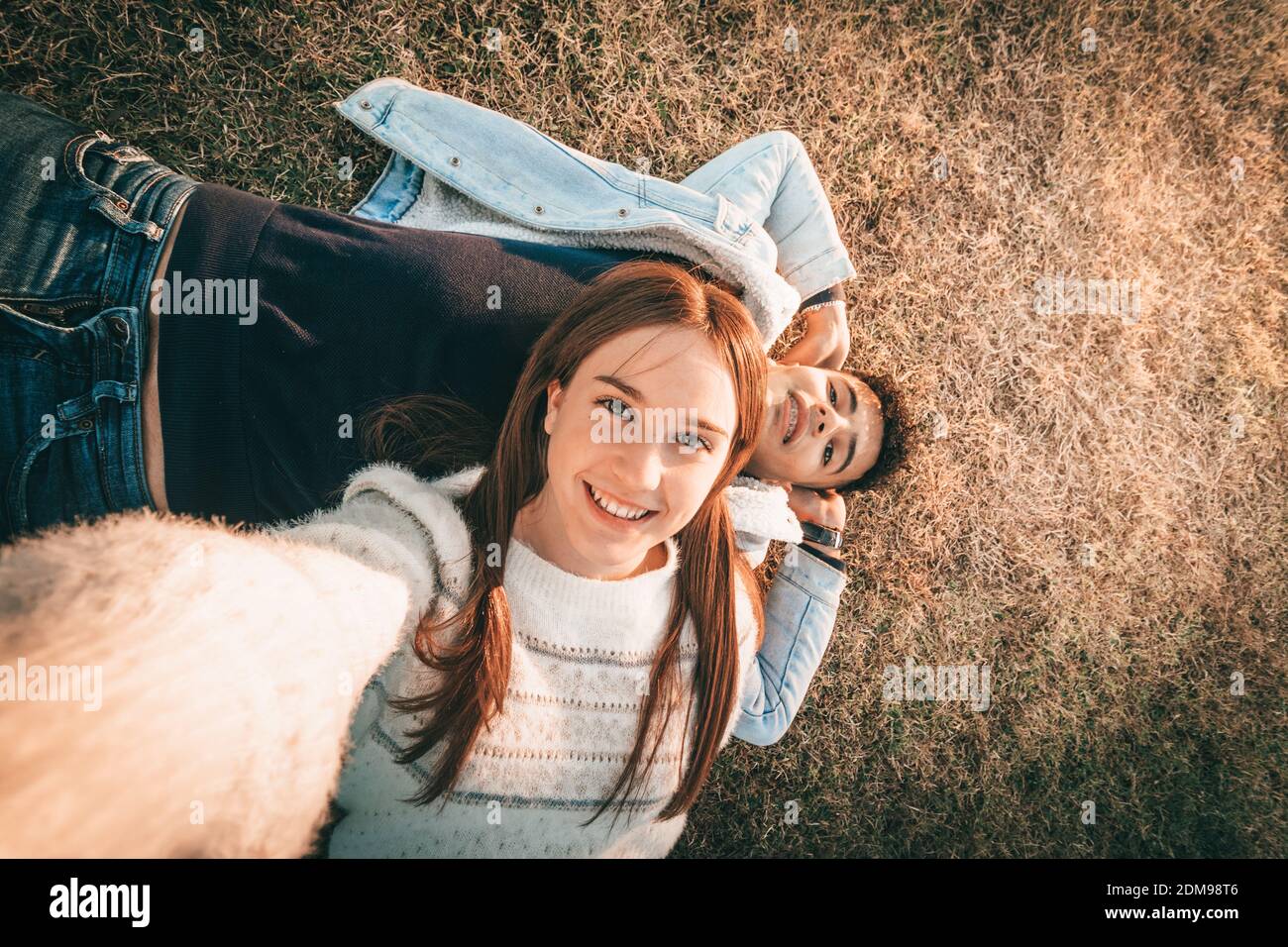Photo aérienne d'UN couple souriant couché sur l'herbe Banque D'Images
