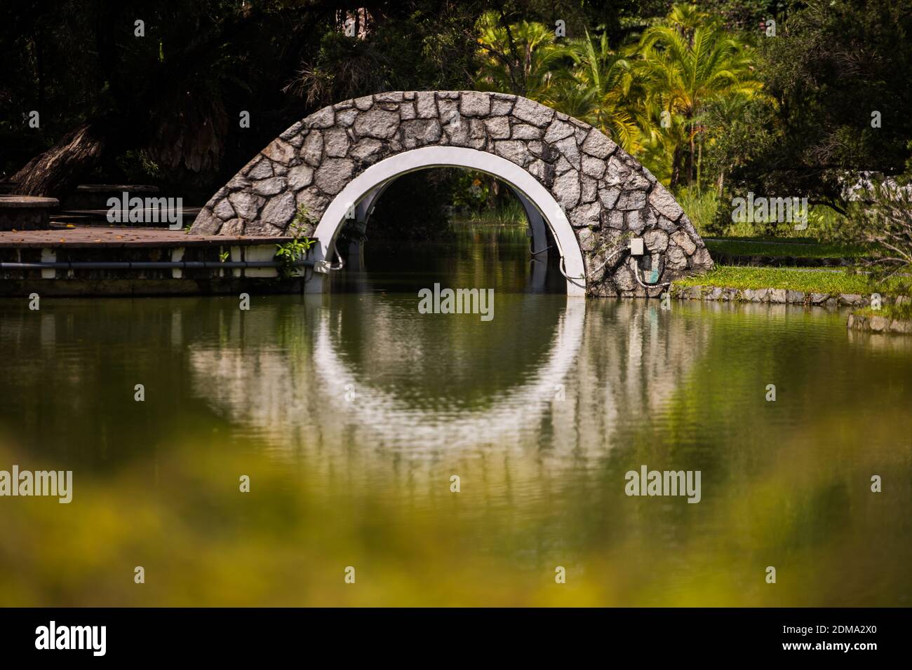 Pont d'arche et réflexion sur l'eau dans un parc de sérénité. Singapour Banque D'Images