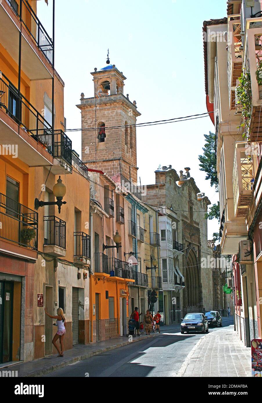 Vie de rue dans la vieille ville d'Orihuela, Espagne. La tour de l'église et la porte vers le bout de la rue sont de l'église paroissiale de Santiago Apostol. Banque D'Images