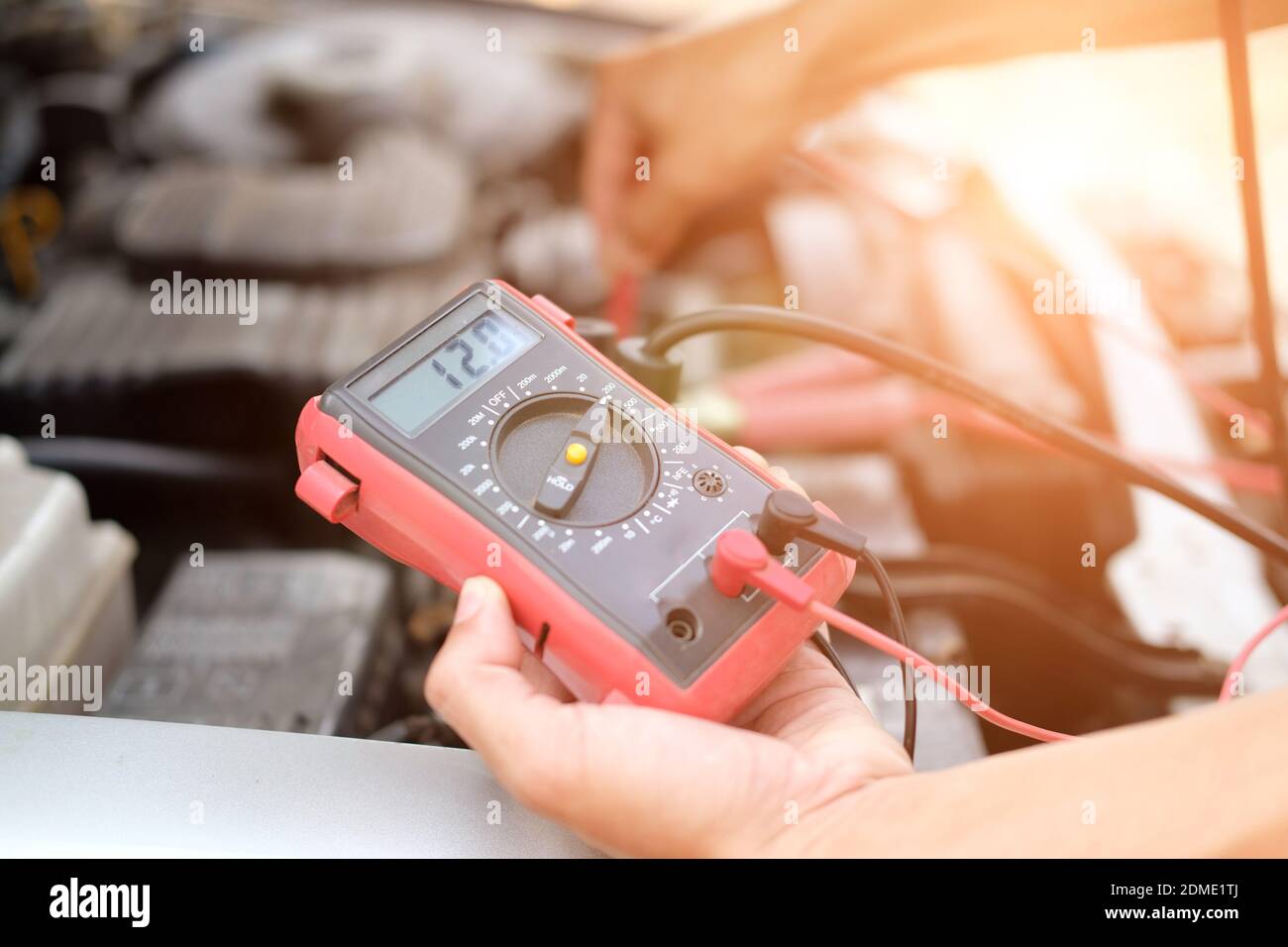Mécanicien auto voiture vérifier la tension de batterie en position  voltmètre multimètre à la station service de réparation Photo Stock - Alamy