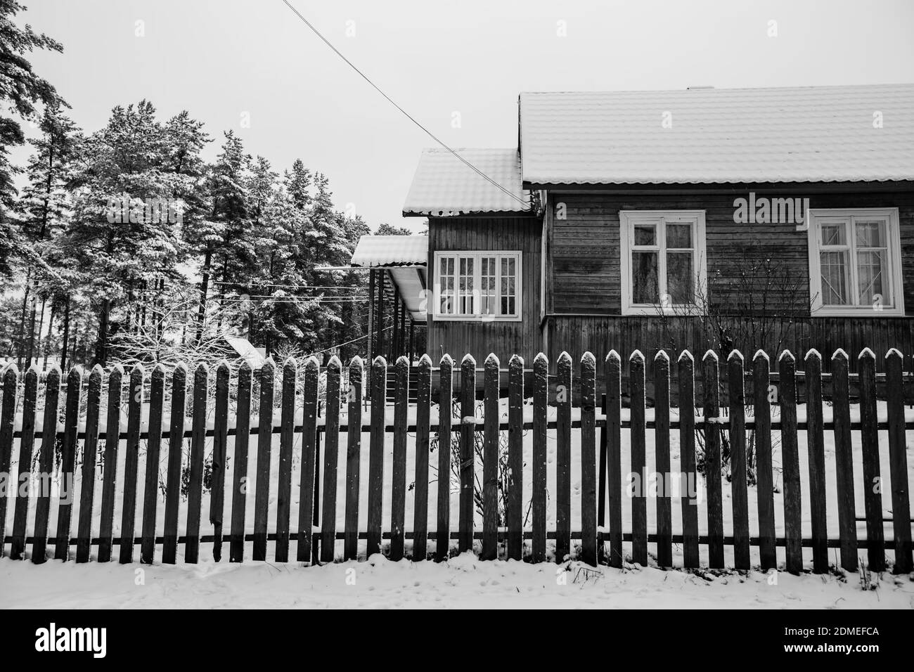 Bâtiments résidentiels en hiver enneigé dans le village dans le nord de la Russie. Photo en noir et blanc. Banque D'Images