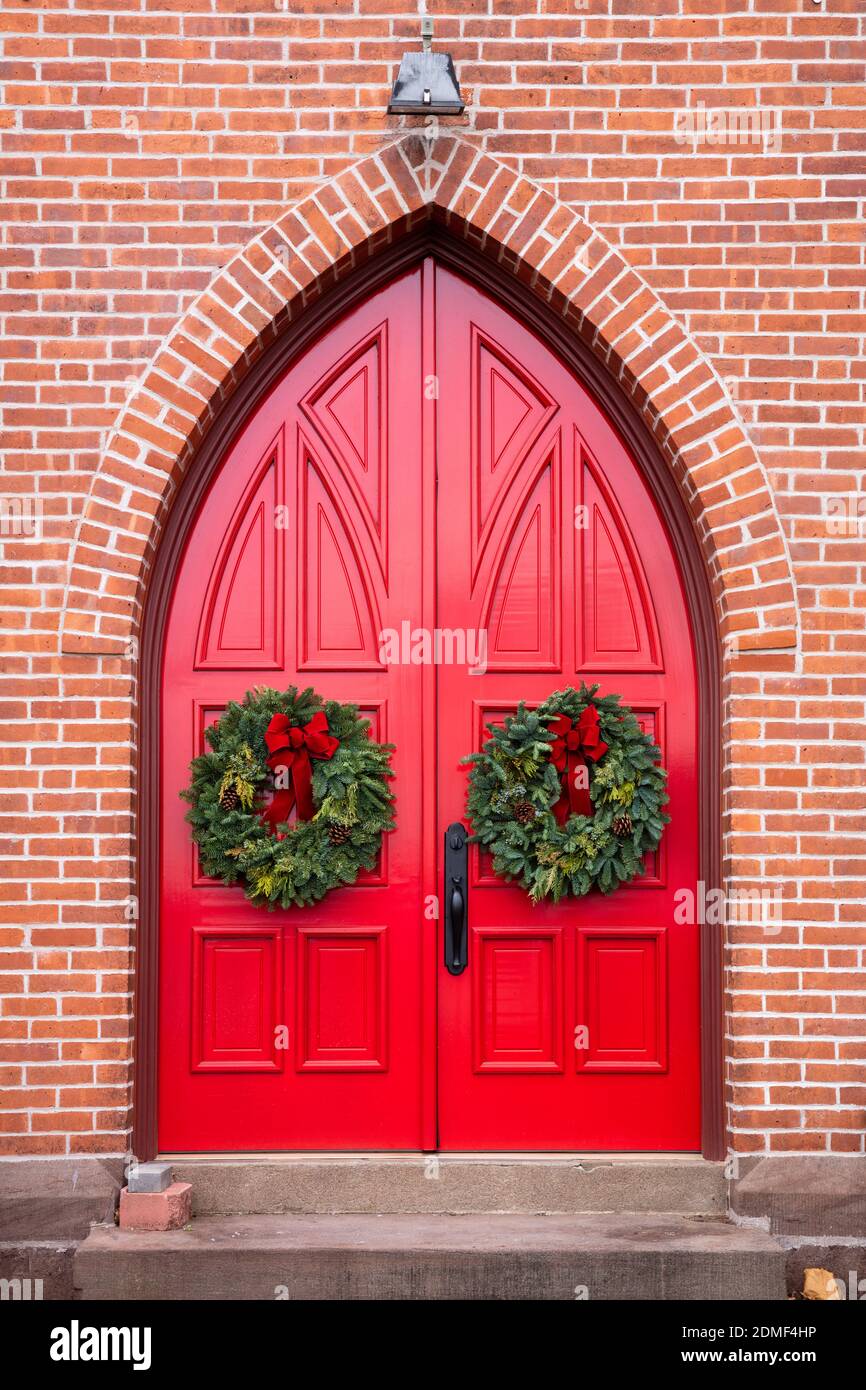 Portes rouges avec couronnes à Noël, église épiscopale Saint-Pierre, Connecticut Banque D'Images