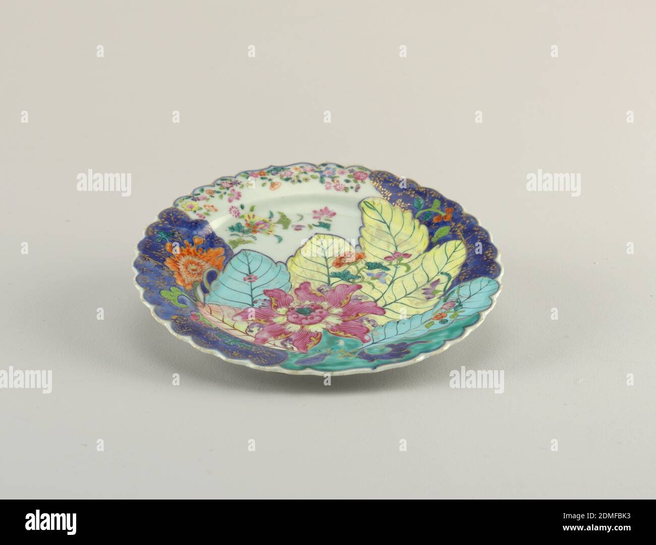 Plaque, porcelaine, émail, dorure, plaque circulaire, centre concave, rebord festonné. Surface supérieure peinte en rose, jaune, bleu, avec des zones bleu sous-brillant et des détails dorés. Peint à l'envers avec des branches florales bleu et rouge sous-glaçantes., Chine, ca. 1850–80, céramique, Arts décoratifs, assiette Banque D'Images Plaque, porcelaine, émail, dorure, plaque circulaire, centre concave, rebord festonné. Surface supérieure peinte en rose, jaune, bleu, avec des zones bleu sous-brillant et des détails dorés. Peint à l'envers avec des branches florales bleu et rouge sous-glaçantes., Chine, ca. 1850–80, céramique, Arts décoratifs, assiette Banque D'Images
