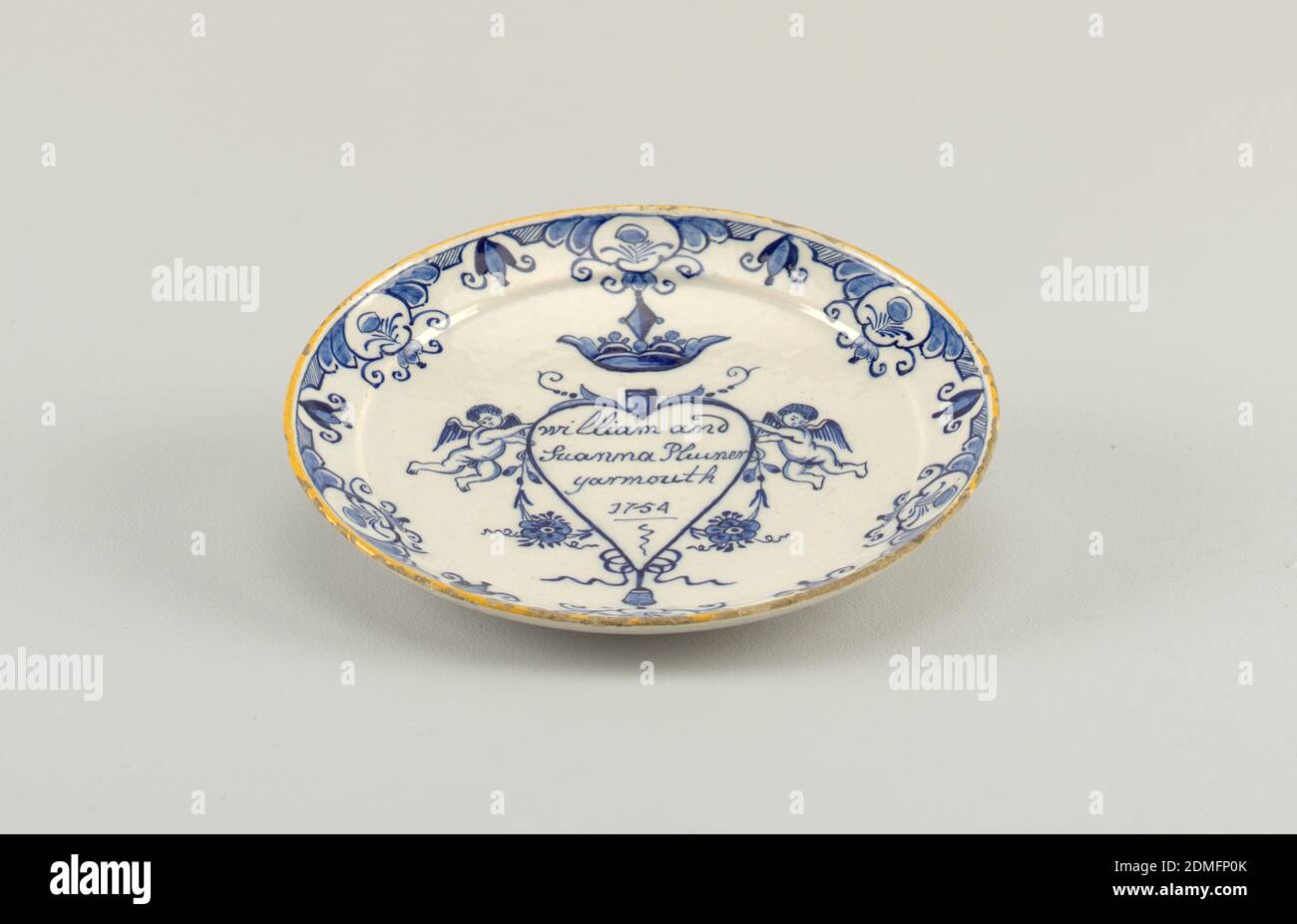 Plaque de mariage, faïence émaillée, plaque circulaire avec rebord courbé; dôme arrière, aplati au centre; peint en bleu et jaune sous-glaçure sur blanc avec un coeur surmonté d'une couronne et entouré de putti et de fleurs, inscrit à l'intérieur de 'William et / Suanna Plumer / Yarmouth / 1754'; Une bordure florale stylisée avec une bordure jaune., Delft, pays-Bas, 1754, céramique, Arts décoratifs, plaque de mariage Banque D'Images
