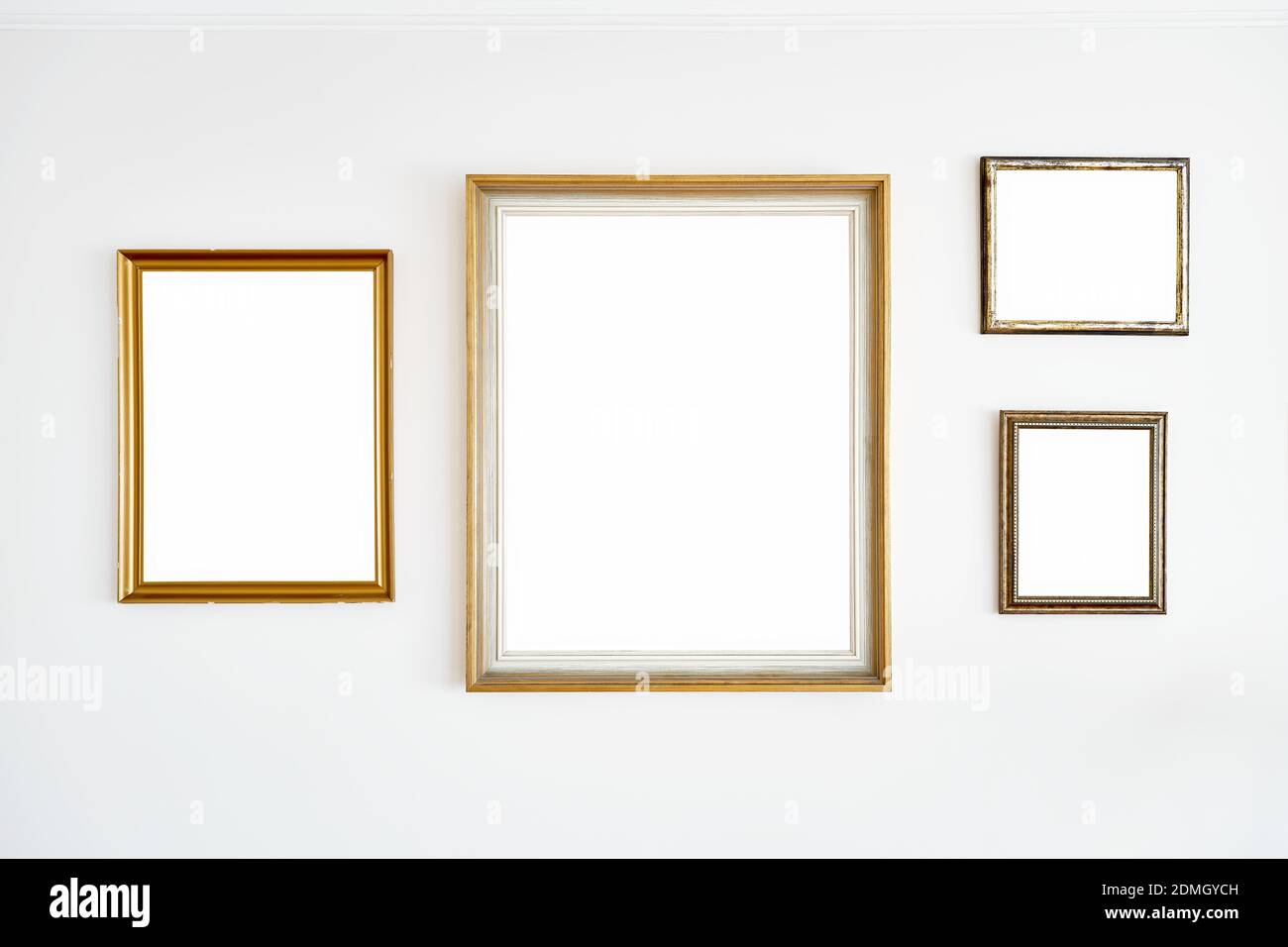 Cadres dorés blancs vintage suspendus sur un mur blanc Banque D'Images
