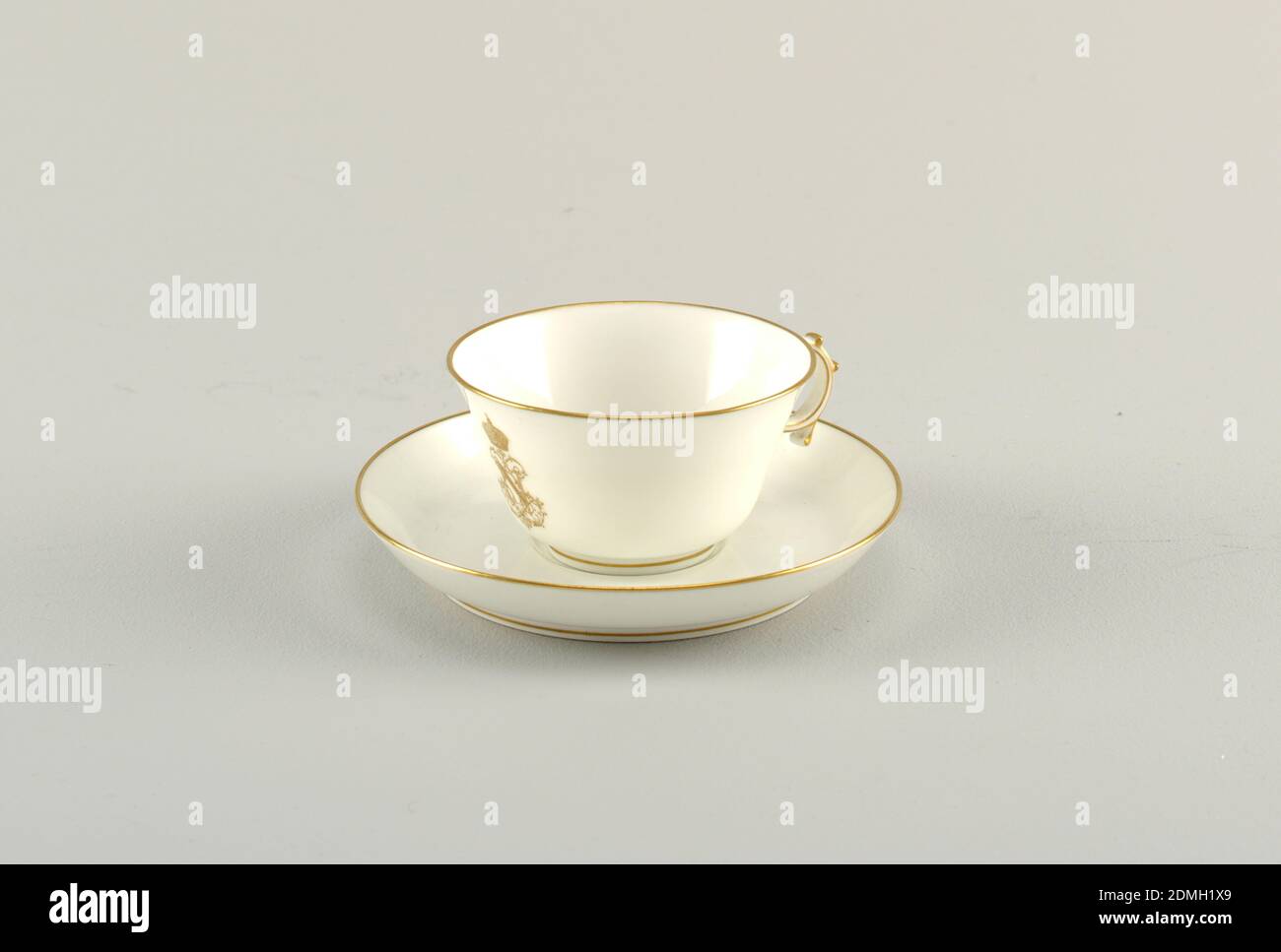 Tasse et soucoupe, du Service des Offices, manufacture de porcelaine de Sèvres, française, établie en 1756 à nos jours, porcelaine à pâte dure, or, tasse Napoléon III peu profonde avec bords évasés. Poignée circulaire avec boutons. Soucoupe plate avec bords incurvés. Dorure sur tous les bords et chiffre couronné sur la tasse., France, 1849–1859, céramique, Arts décoratifs, coupe et soucoupe, coupe et soucoupe Banque D'Images